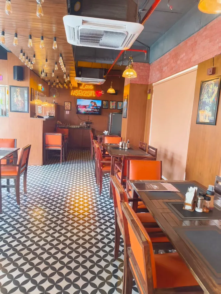 Corner tables with orange leather chairs in daylight