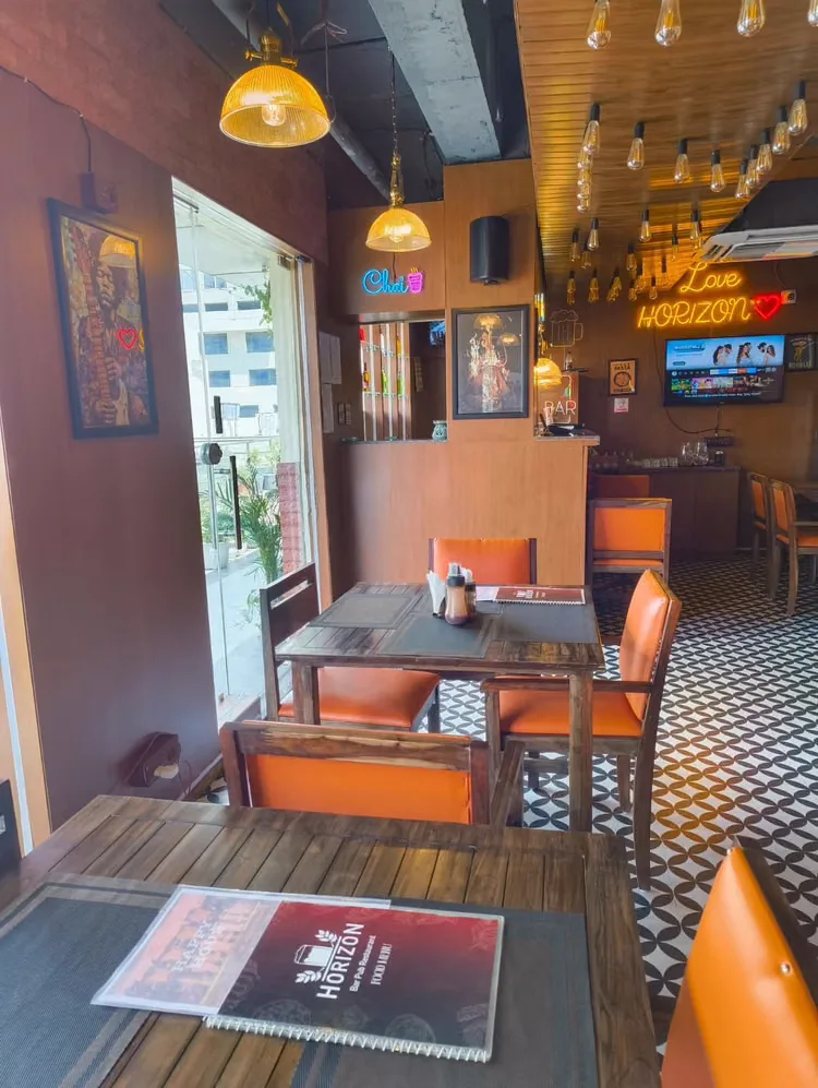 Main dining area with dark wood tables, orange leather chairs and patterned tile floor