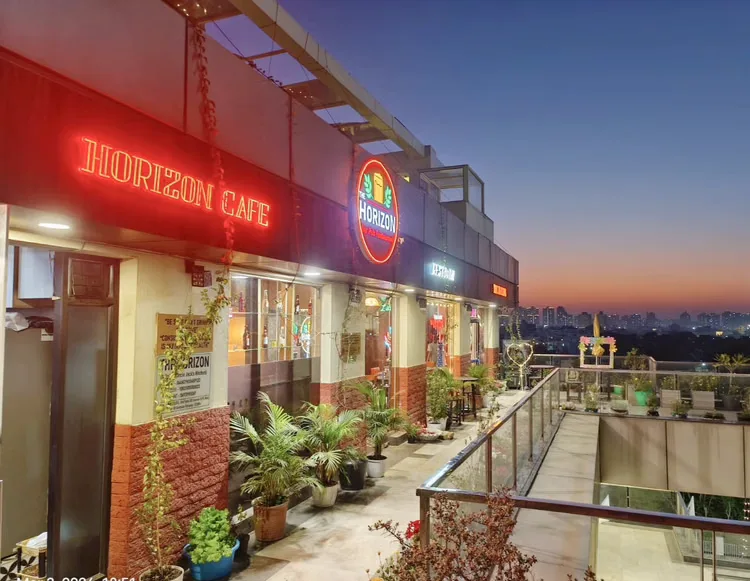 The Horizon Cafe sign glowing on the facade as the sky turns to dusk