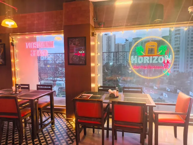 Indoor dining corner lit by the Horizon neon logo