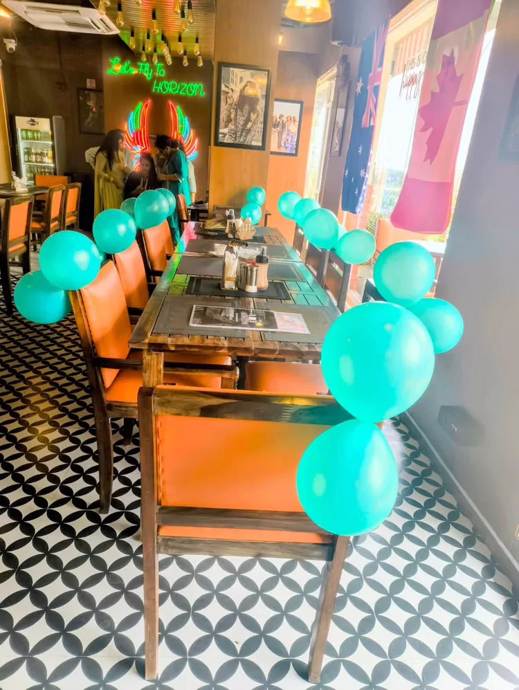 Tables decorated with teal balloons for a private celebration