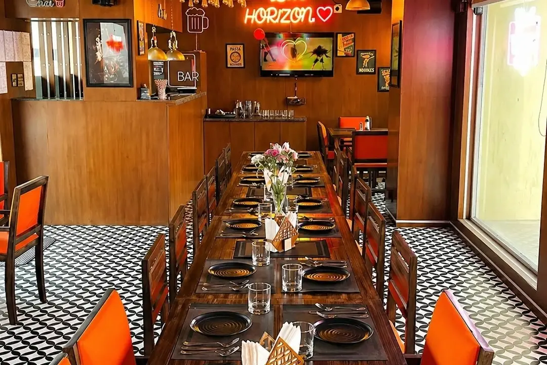 A long table laid for ten with black platters and cutlery