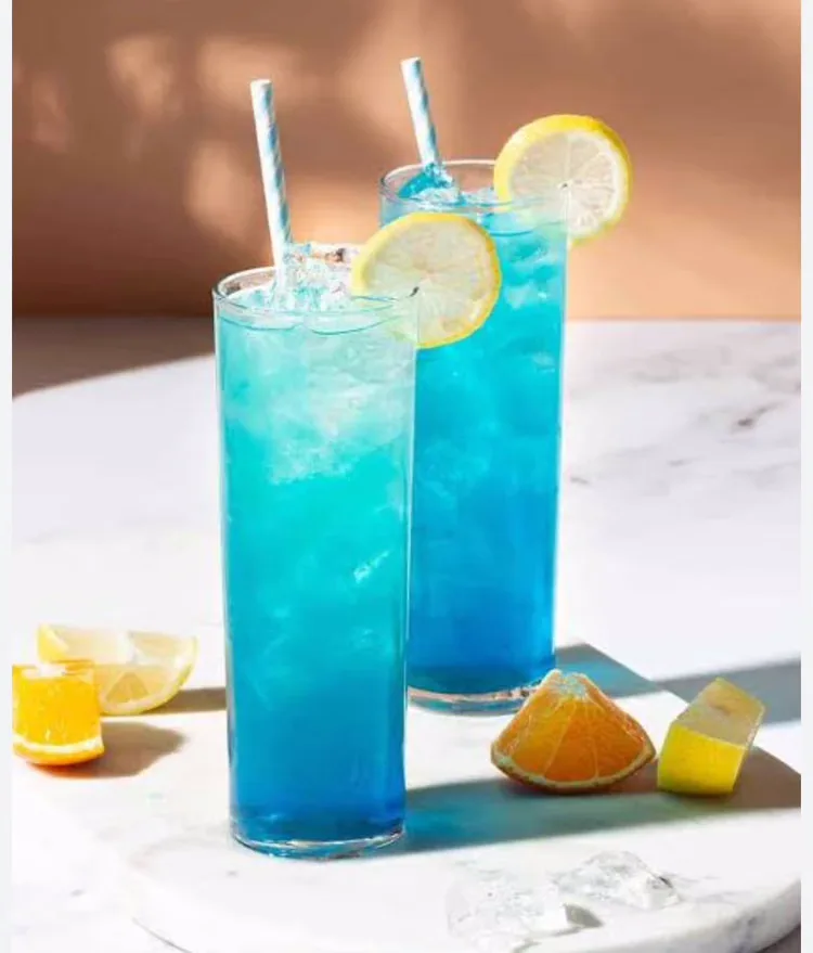 Two tall blue lagoon coolers with lemon wheels
