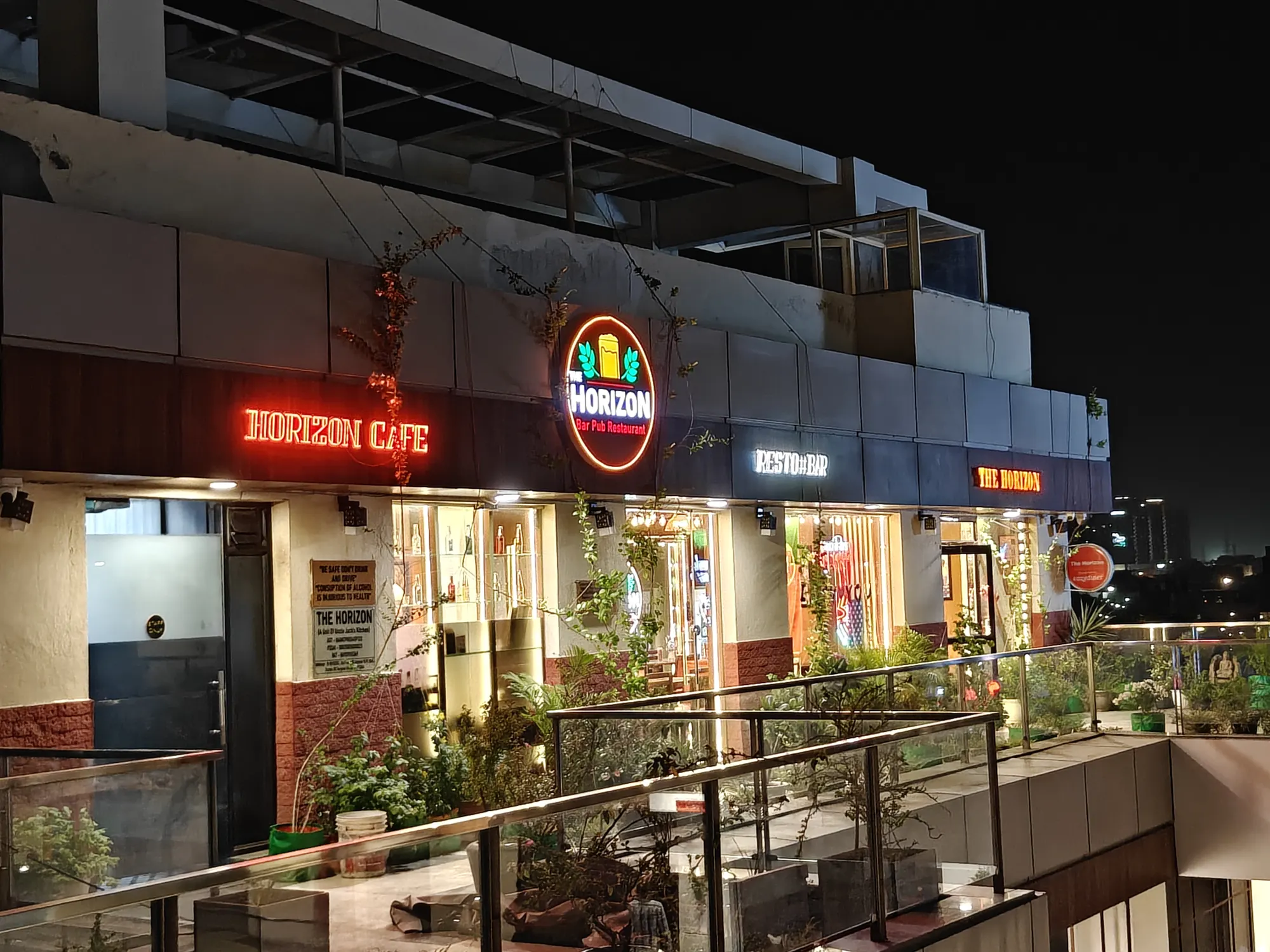 The Horizon's glowing signs on the rooftop facade, with the city lights behind