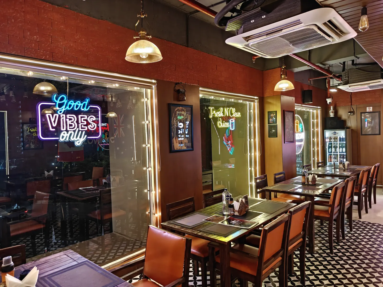 The Good Vibes Only neon glowing over the tables