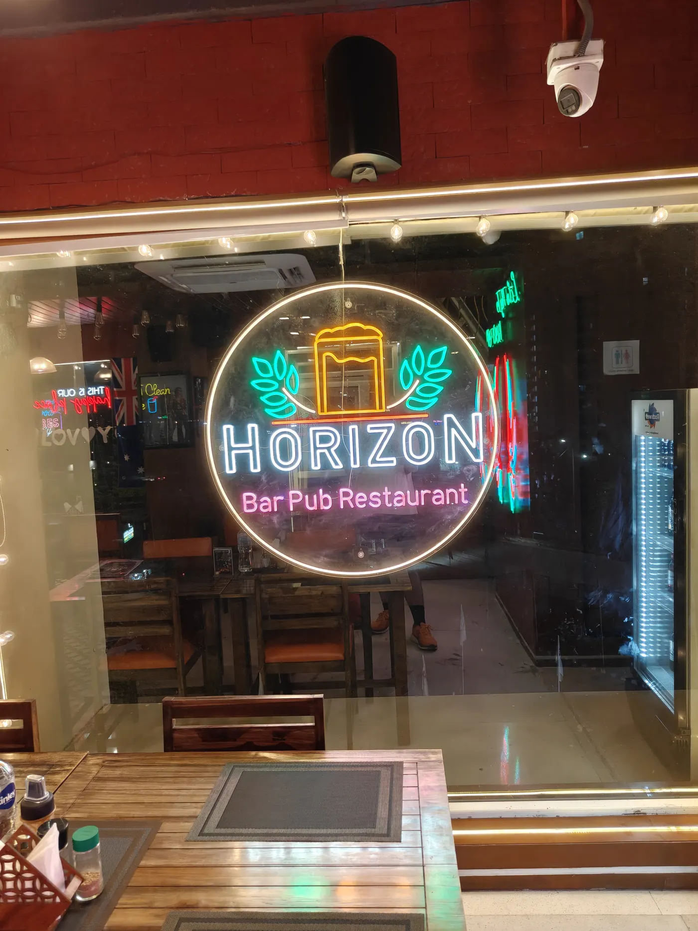 The round Horizon Bar Pub Restaurant neon through the window